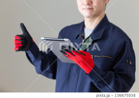 タブレットを持って親指を立てる作業服のミドル男性ビジネスマン 136675038