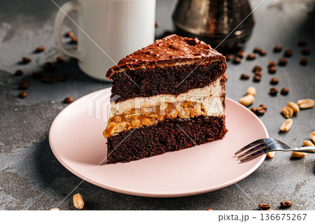Chocolate cake slice with cream and peanuts Chocolate cake slice with cream and peanuts 136675267