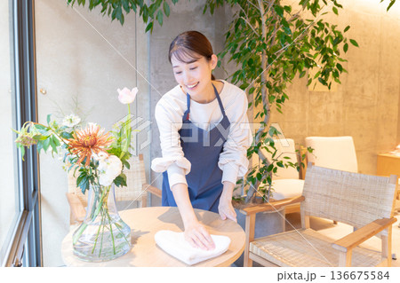 カフェのテーブルを拭く若い女性店員 136675584