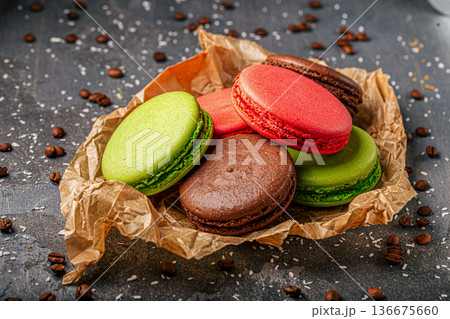 Colorful macarons on paper with coffee beans Colorful macarons on paper with coffee beans 136675660