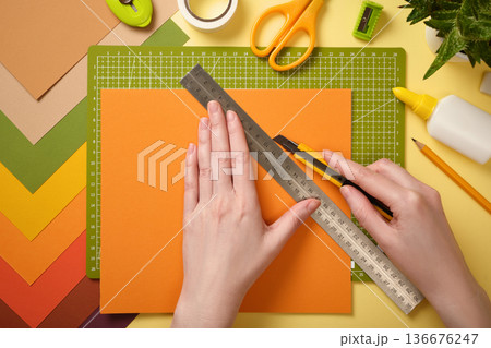 Hands cut paper with a utility knife. Cutting mat, scissors, glue, and stationery. Paper craft process. Hands cut paper with a utility knife. Cutting mat, scissors, glue, and stationery. Paper craft process. 136676247