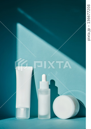 Skincare cosmetic products minimalist merchandising on blue background Skincare cosmetic products minimalist merchandising on blue background 136677208