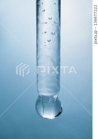 Icicle slowly melting, clear water droplet ready to fall 136677222