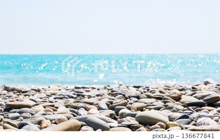 Pebble beach with the sea in the background and bokeh effects on the water. 136677841