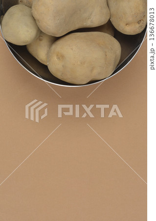 Raw potatoes in a metal bowl with copy space Raw potatoes in a metal bowl with copy space 136678013