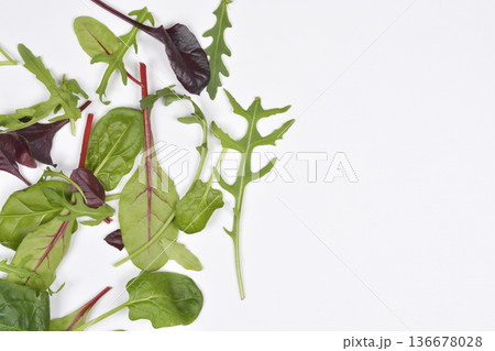 Mixed baby salad leaves on white background Mixed baby salad leaves on white background 136678028