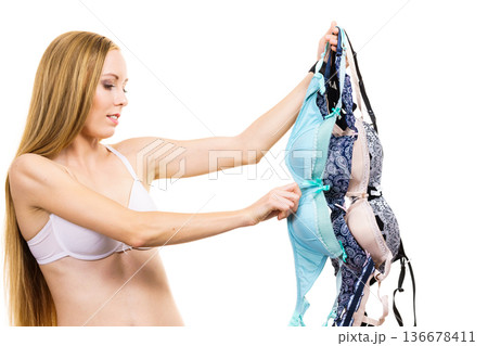 Woman holds bras, choosing 136678411