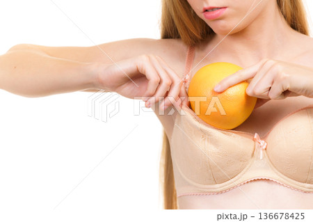 Woman small boobs puts big fruit in her bra 136678425