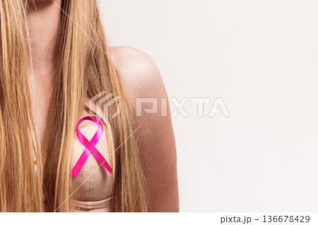 Woman chest in bra, pink cancer ribbon Woman chest in bra, pink cancer ribbon 136678429