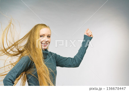 Smiling woman with blowing long hair Smiling woman with blowing long hair 136678447