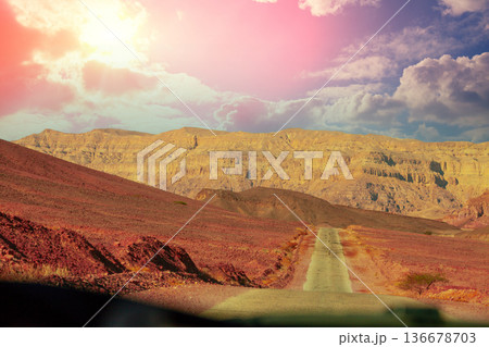 Driving a car on mountain Israel road. Desert landscape. Empty road. View from car of mountain landscape on a sunny day. Israel Driving a car on mountain Israel road. Desert landscape. Empty road. View from car of mountain landscape on a sunny day. Israel 136678703