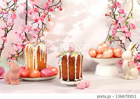 Happy Easter concept, abstract Easter composition featuring a traditional Russian meringue kulich and painted eggs on elegant kitchen table with spring cherry blossoms, banner for a greeting message 136678951