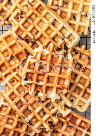 Delicious belgian waffles on baking cooling rack close up, top view. Texture 136679603