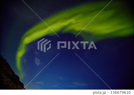 Aurora borealis over ocean in Teriberka, Russia, Murmansk region, Northern lights, Starry sky with polar lights and clouds. Night autumn landscape with bright aurora, stars, sea 136679610