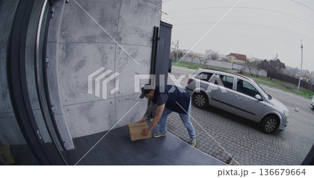 Courier in Silver Car Places Parcel on Porch and Takes Smartphone Photo For Confirmation Courier in Silver Car Places Parcel on Porch and Takes Smartphone Photo For Confirmation 136679664