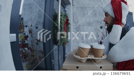 Santa Delivers Stacks of Pizza Boxes and Takeaway Coffee Cup to Young Woman Santa Delivers Stacks of Pizza Boxes and Takeaway Coffee Cup to Young Woman 136679691