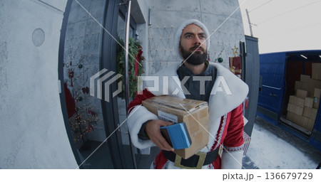 Santa Claus Delivers Package to Woman at Doorstep 136679729