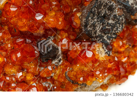 macro mineral stone Spessartine, orange, red garnet with quartz on white background macro mineral stone Spessartine, orange, red garnet with quartz on white background 136680342