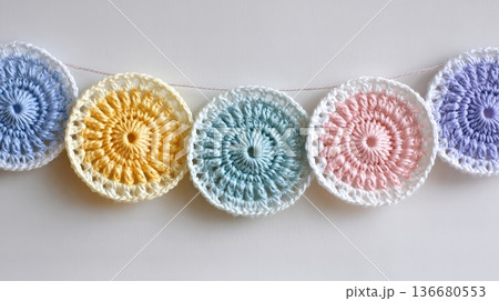 Crochet Garland With Circular Designs in Pastel Colors Hanging on a Plain Background Crochet Garland With Circular Designs in Pastel Colors Hanging on a Plain Background 136680553