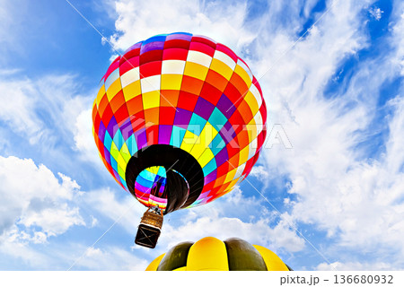 Colorful hot air balloon flying over blue sky with white clouds Colorful hot air balloon flying over blue sky with white clouds 136680932