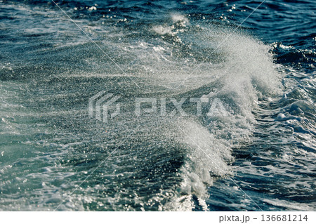 A wave of the Barents Sea breaks against a strong wind in sunny weather 136681214