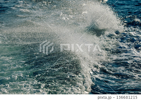 A wave of the Barents Sea breaks against a strong wind in sunny weather 136681215