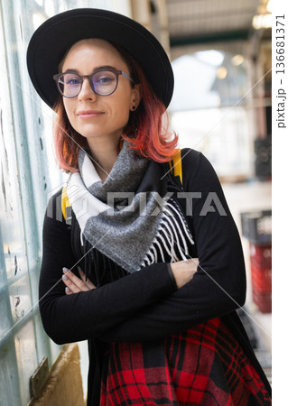 Young woman with red hair wearing stylish hat and glasses 136681371