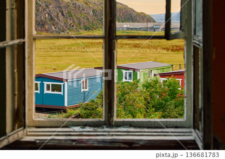 Weathered wooden houses in Teriberka at dusk, Russia, Kola Peninsula, evoke a bygone era, standing as silent witnesses to the passage of time. Teriberka's historical architecture concept Weathered wooden houses in Teriberka at dusk, Russia, Kola Peninsula, evoke a bygone era, standing as silent witnesses to the passage of time. Teriberka's historical architecture concept 136681783