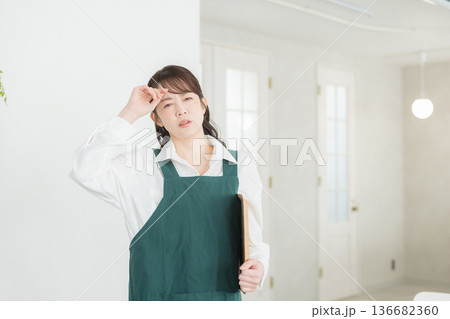 エプロンを着た笑顔の女性　 136682360