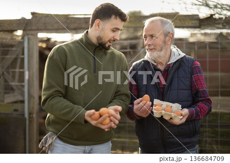 Man with senior father presents farms eco-friendly products - chicken eggs 136684709