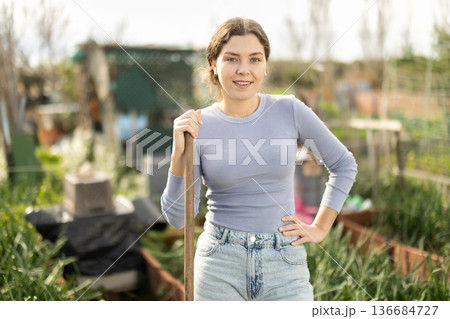 Young woman while working in garden Young woman while working in garden 136684727