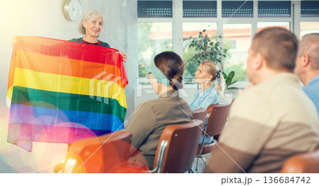 Elderly female tutor with rainbow flag lecturing for group of seniors Elderly female tutor with rainbow flag lecturing for group of seniors 136684742