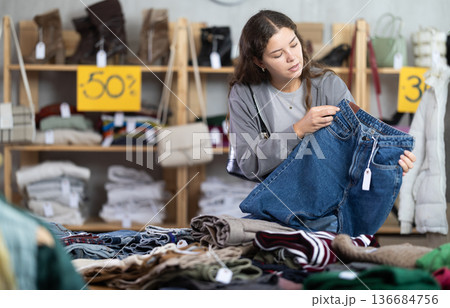 During November sales, young woman choose and buy jeans trousers During November sales, young woman choose and buy jeans trousers 136684756
