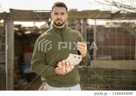 Man holding fresh eggs in chicken coop Man holding fresh eggs in chicken coop 136684800