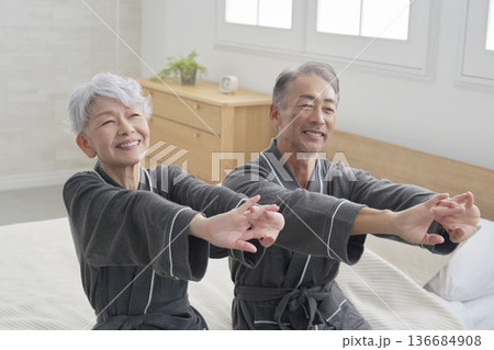 寝室で腕のストレッチをするシニア夫婦 136684908