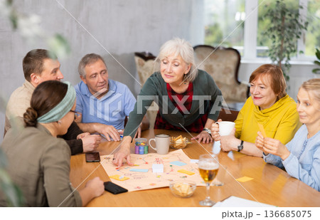 Group of positive older people playing tabletop game 136685075