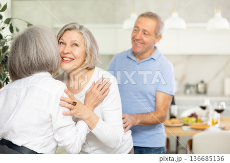 As two elderly woman meet, they exchange warm greeting by embracing with a gentle kiss on cheek As two elderly woman meet, they exchange warm greeting by embracing with a gentle kiss on cheek 136685136