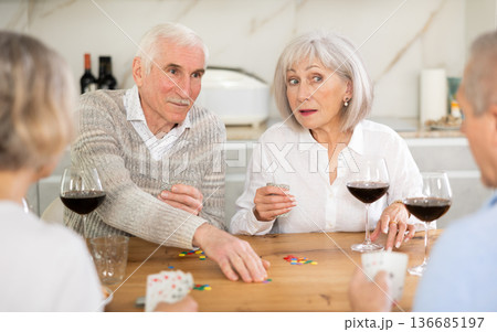 Couples of elderly women and men playing poker Couples of elderly women and men playing poker 136685197