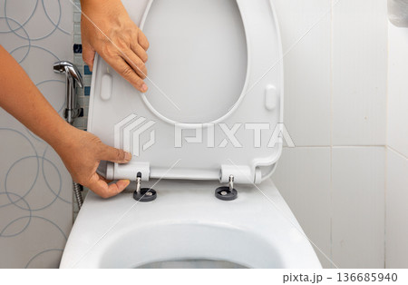 Worker replace hinge rubber plug and Screws for Toilet Seat 136685940