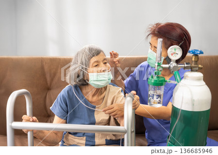 Elderly woman wearing oxygen nasal cannula at home. Elderly woman wearing oxygen nasal cannula at home. 136685946