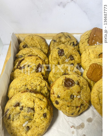 Freshly baked cookies with a golden-brown finish and chocolate chips. Perfectly crisp on the edges with a soft center, offering a delicious, comforting treat for any occasion. Freshly baked cookies with a golden-brown finish and chocolate chips. Perfectly crisp on the edges with a soft center, offering a delicious, comforting treat for any occasion. 136687773