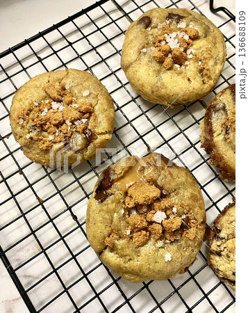 Freshly baked cookies with a golden-brown finish and chocolate chips. Perfectly crisp on the edges with a soft center, offering a delicious, comforting treat for any occasion. 136688109