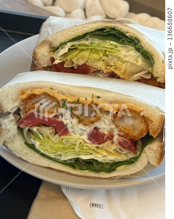 Delicious sandwich filled with fresh ingredients like crisp vegetables, tender meats, and savory spreads, all between two slices of soft bread. Perfect for a quick and satisfying meal. 136688607