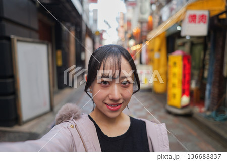 東京のレトロな商店街で自撮りをする若い女性 136688837