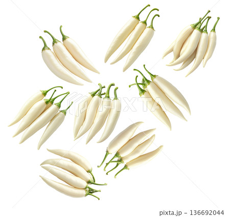 Fresh white chili peppers with green stems arranged in groups, isolated on a white background. Concept of spicy food 136692044