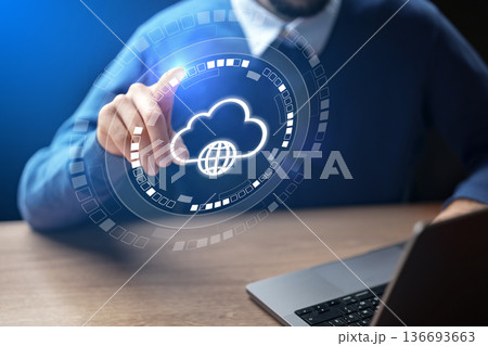 Man uses technology to interact with cloud services on a laptop in a workspace setting 136693663