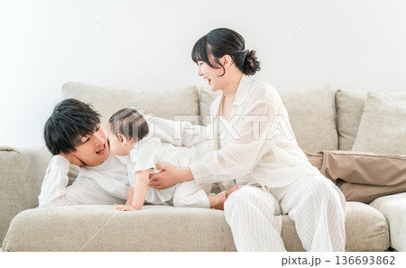マイホームのリビングソファーで赤ちゃんと過ごす若いファミリー,家族 136693862
