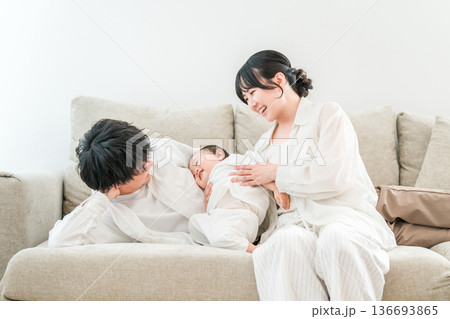 マイホームのリビングソファーで赤ちゃんと過ごす若いファミリー,家族 マイホームのリビングソファーで赤ちゃんと過ごす若いファミリー,家族 136693865