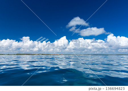 clouds on blue sky over calm sea with sunlight reflection clouds on blue sky over calm sea with sunlight reflection 136694823