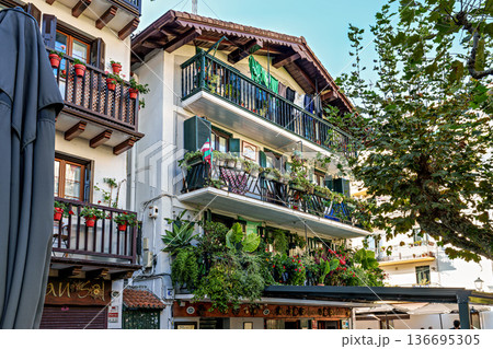 Colorful Buildings, Red Shutters, Flower Balconies, Cobblestone Street, Traditional Architecture in Hondarribia, Spain Colorful Buildings, Red Shutters, Flower Balconies, Cobblestone Street, Traditional Architecture in Hondarribia, Spain 136695305